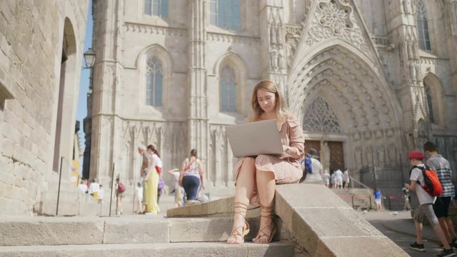 Business woman sitting with laptop outdoor. Girl getting message on computer