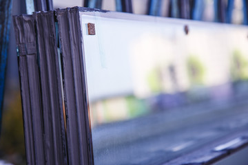 Stack of double-glazed windows ready for installation at a construction site. Selected defective...