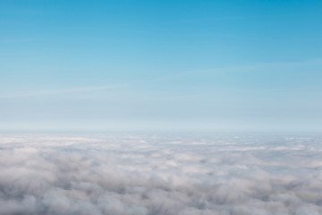 bird eye view at clouds in blue sky top view from drone from airplane window