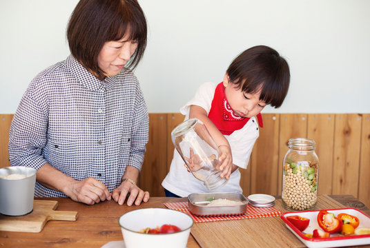 Japanese woman and boy standing in a farm shop, preparing food.