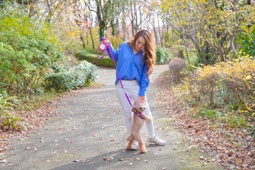 ペットと公園を散歩する女性