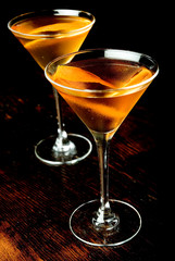 Mixed cocktail in two martini glasses with black background