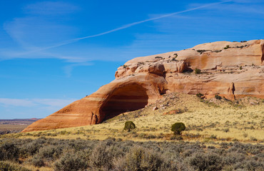 A natural rounded cave shows the beauty of the sandstone's colors and patterns.