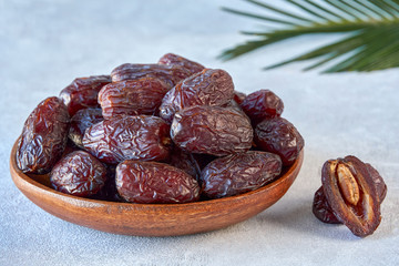 Dried dates fruit in wooden bowl . Close up 