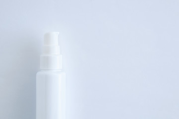 White plastic bottle with dispenser closeup. White background.