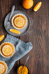 Whole-wheat turmeric tartlets filled with apricot jam, decorated with dried oranges, topped with powdered sugar
