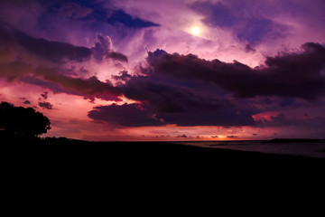 Heavy thunderstorm with rain at night on the shore with lightning and strong wind.