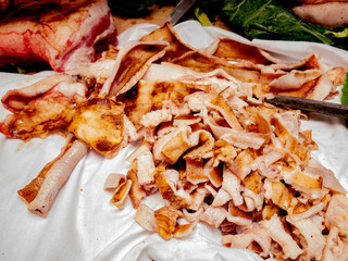 Pork skin cut into pieces and burned with incasdescent iron for sausage manufacturing