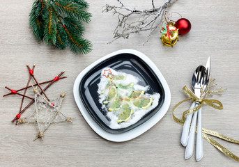 Plate, knife, fork and a variety of Christmas decorations on a table close-up.