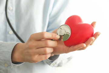 Medical worker holding a red heart as a symbol of health, health care  concept