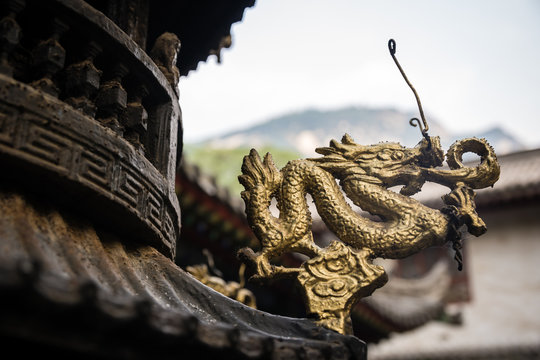 Golden dragon sculpture decoration on a wooden temple roof