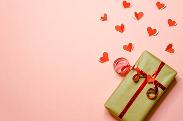 gift with red ribbon and hearts flying out of it in recognition of love on trendy pink background...