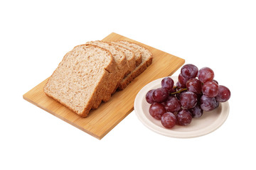 Whole grain bread and grapes isolated on white background..