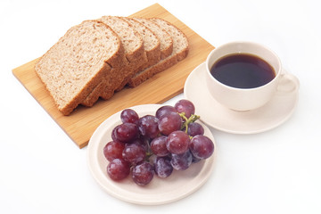 Whole grain bread and grapes serve with a cup of coffee..