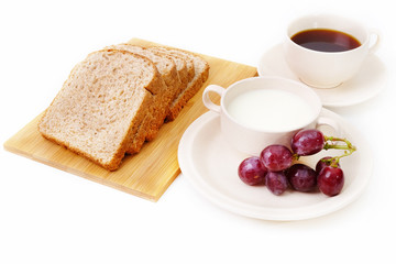 Whole grain bread, grapes and milk serve with a cup of coffee..