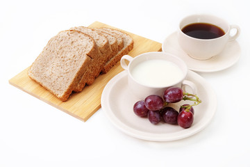 Whole grain bread, grapes and milk serve with a cup of coffee..