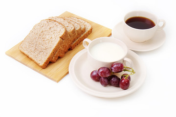 Whole grain bread, grapes and milk serve with a cup of coffee..