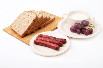 Whole grain bread, sausages and grapes serve with milk..