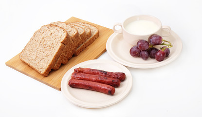 Whole grain bread, sausages and grapes serve with milk..