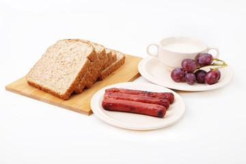 Whole grain bread, sausages and grapes serve with milk..