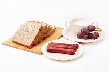 Whole grain bread, sausages and grapes serve with milk..