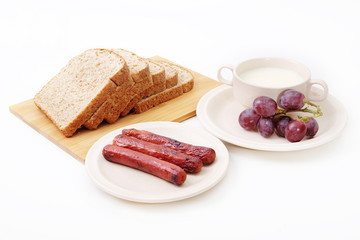 Whole grain bread, sausages and grapes serve with milk..