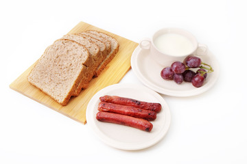Whole grain bread, sausages and grapes serve with milk..