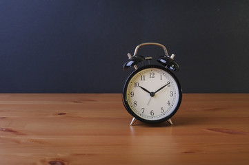 Alarm clock on top of wooden table.