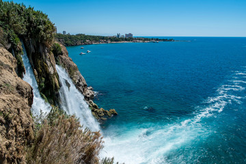 Waterfall Duden at Antalya turkey top view on the mountain with coast ferry boat on blue sea and harbor city background - Beautiful antalya beach Turkey landscape travel landmark