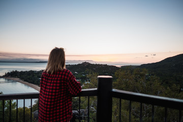 Fototapeta na wymiar Magnetic island, Australia: Young girl enjoying view from the platform on the Hawkings point track during sunset, beautiful colourful pink sky