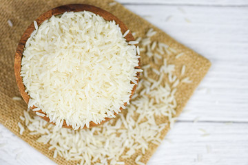 Thai rice white on wooden bowl and the sack / raw jasmine rice grain agricultural products for food in Asian
