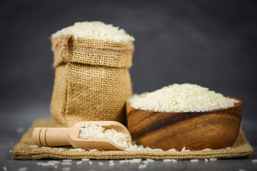 Fototapeta na wymiar Thai rice white on bowl and the sack / raw jasmine rice grain agricultural products for food in Asian