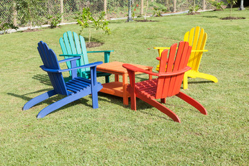 set of wooden chairs painted with vibrant colors; Photo in natural environment.