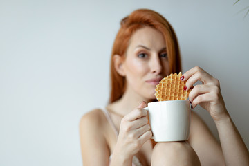 Ginger woman eating a biscuit