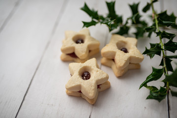 Christmas shortbread star cookies with strawberry jam. Festive atmosphere holiday pastry baking concept.