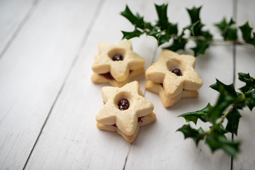 Christmas shortbread star cookies with strawberry jam. Festive atmosphere holiday pastry baking concept.