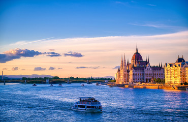 The Hungarian Parliament Building located on the Danube River in Budapest Hungary at sunset.