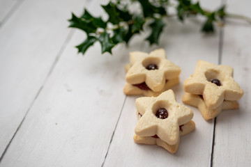 Christmas shortbread star cookies with strawberry jam. Festive atmosphere holiday pastry baking concept.