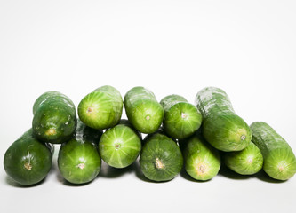 piles of mini cucumbers isolated on white.