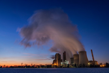 Coal-fired power plant Eschweiler-Weisweiler, Germany, at dusk in winter. Steam rising from coolers.