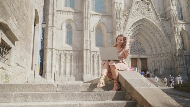 Pretty woman working laptop outdoor. Smiling businesswoman looking laptop screen