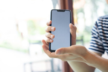 businessman hands searching for data on mobile phone  with analyzing charts at his workplace.