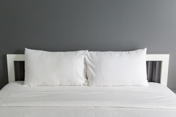 Two white pillow on bed and blanket