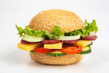 Hamburger with vegetables and sausage on a white background. Fast food and breakfast. Calories and diet.