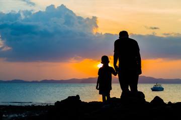 Silhouette image of father and son at the beach