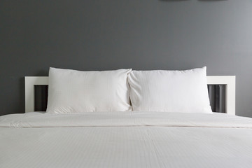 Two white pillow on bed and blanket