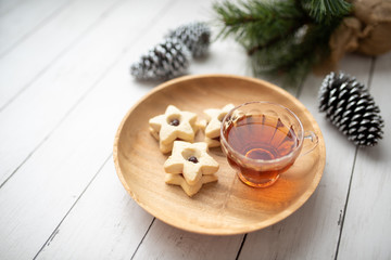 Christmas shortbread star cookies with strawberry jam. Festive atmosphere holiday pastry baking concept. Cookies and tea for Santa