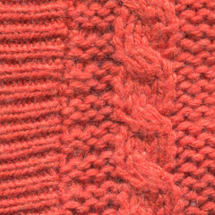 Close-up texture of an orange-red sweater, knitting elements, macro background