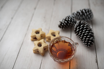 Christmas shortbread star cookies with strawberry jam. Festive atmosphere holiday pastry baking concept. Cookies and tea for Santa