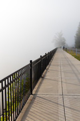 Sidewalk with joggers in the fog